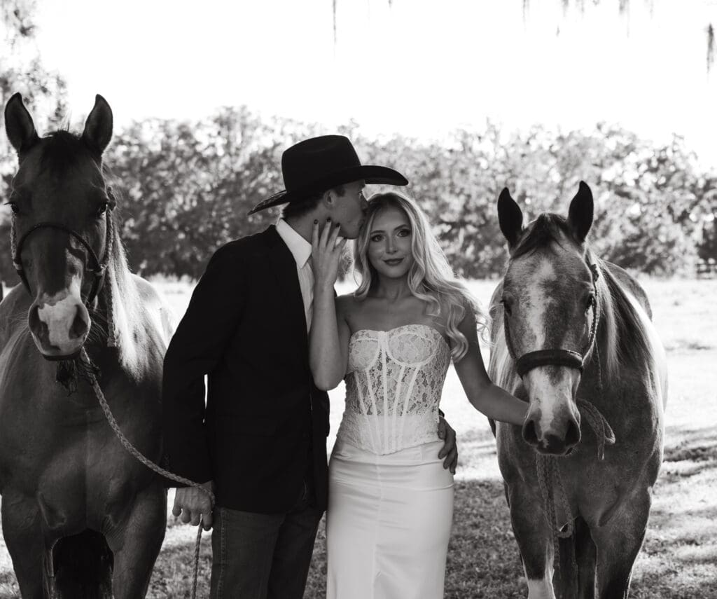 Florida wedding couple posing with horses during a western inspired wedding photographed by Through Her Lens Photography